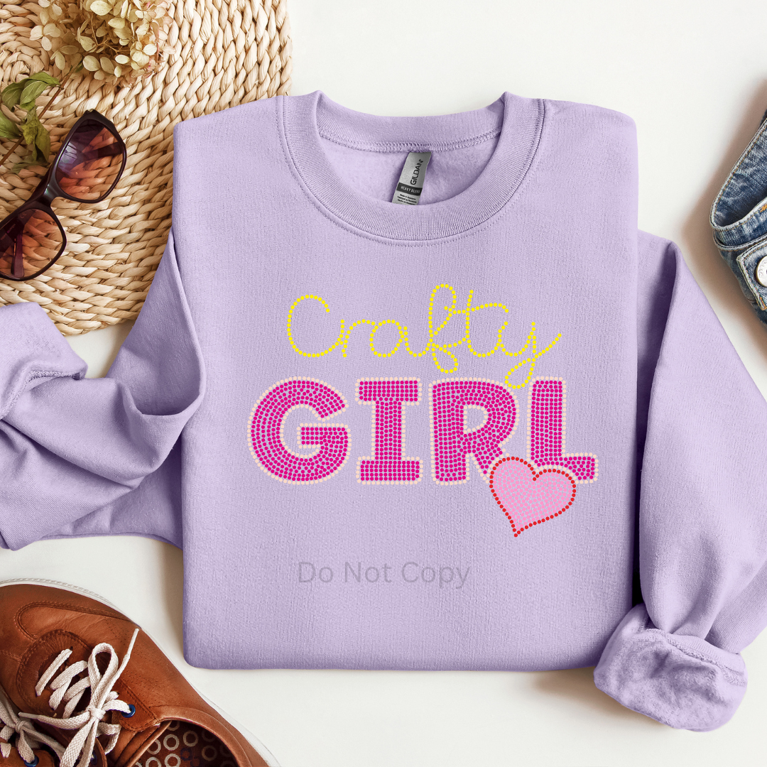 Purple sweatshirt with 'Crafty Girl' text on a white surface
