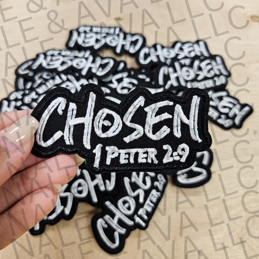 Embroidered patch with 'CHOSEN 1 Peter 2:9' text held by a hand on a beige background.