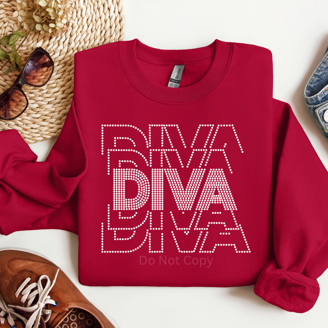 Red sweatshirt with 'DIVA' text on a white surface with accessories around