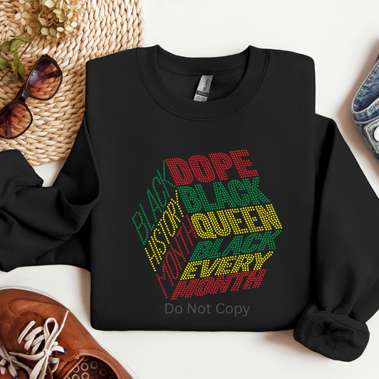 Black sweatshirt with colorful text design on a white surface with accessories around.