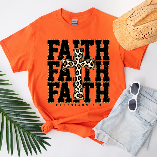 Orange t-shirt with 'FAITH' text and leopard print cross, accompanied by a hat, sunglasses, and shorts on a white background.
