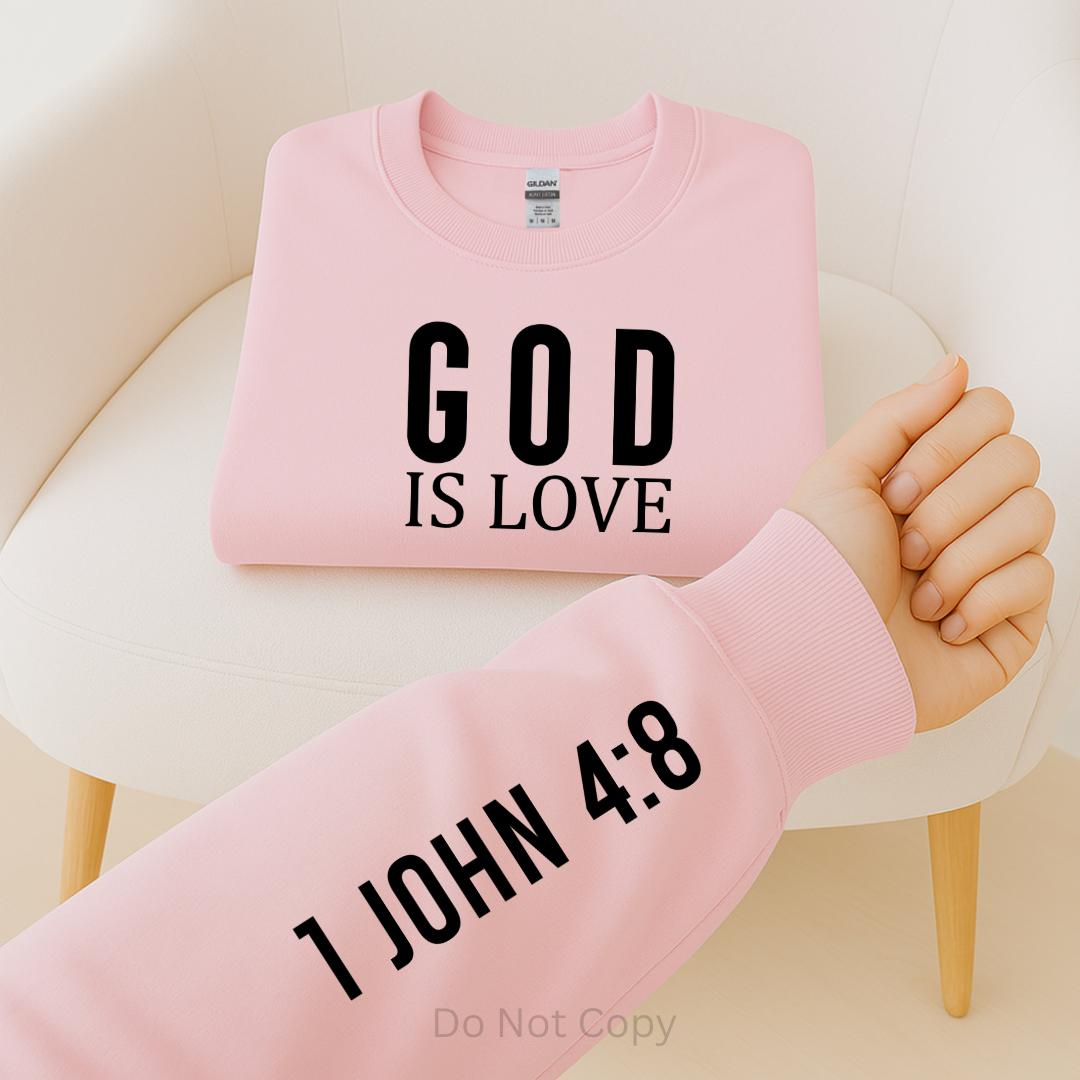 Pink sweatshirt with 'GOD IS LOVE' and '1 JOHN 4:8' text on a light background