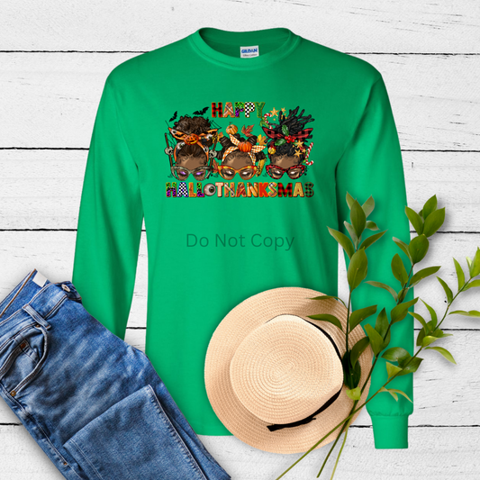 A green long-sleeve shirt with a colorful 'Hallothanksmas' text and graphics transfer on the front. Accompanied by a blue-patterned hat and a pair of jeans, indicating the complete outfit.