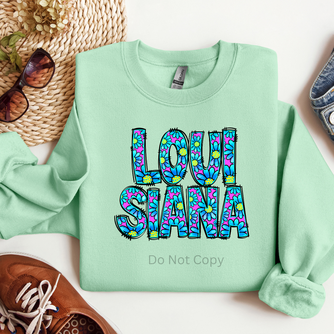 A green sweatshirt with the text 'LOUISIANA' printed in a colorful pattern.