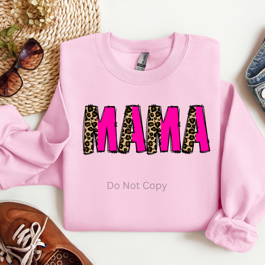 A pink sweatshirt with the text 'MAMA' on it, where the letters 'A' and 'M' are in black and leopard print respectively.