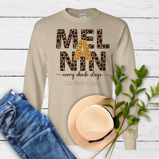 A beige-colored sweatshirt laid out flat with a printed transfer on it that reads 'MELANIN every shade slays' in a leopard print pattern.