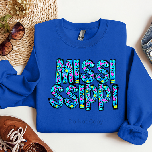 A blue long-sleeved shirt with the text 'Mississippi' printed in a colorful pattern.