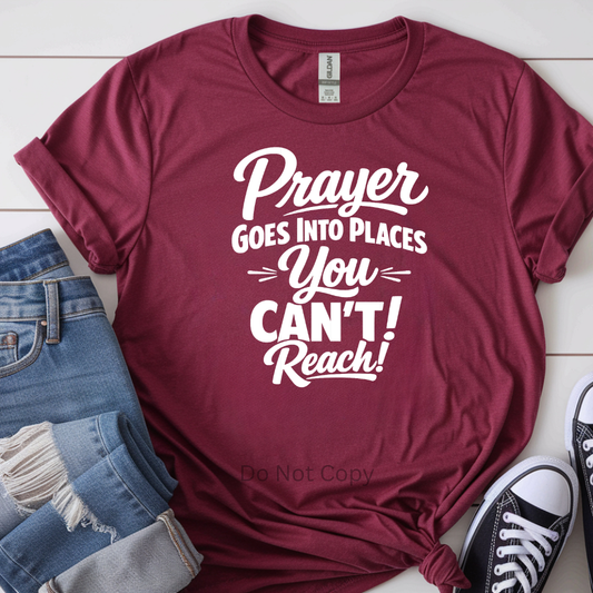 Maroon t-shirt with motivational quote on a white surface with jeans and sneakers.