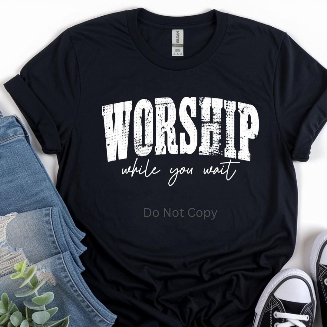 Black t-shirt with 'Worship while you wait' text on a white background