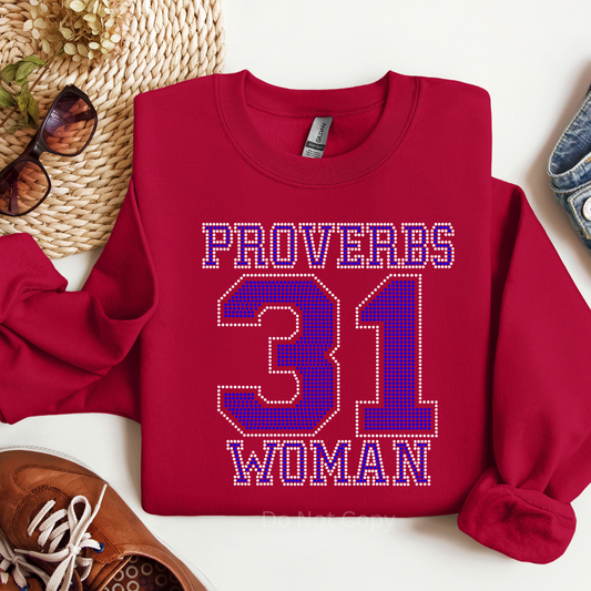 Red sweatshirt with 'Proverbs 31 Woman' text on a white surface with accessories.
