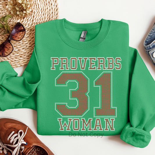 Green sweatshirt with 'Proverbs 31 Woman' text on a white surface with accessories.