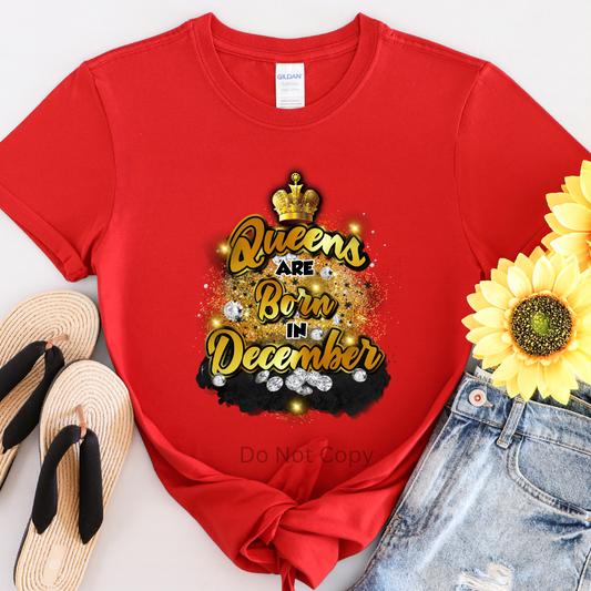 A red T-shirt with the text 'Queens are Born in December' printed on it, accompanied by a crown and decorative elements.