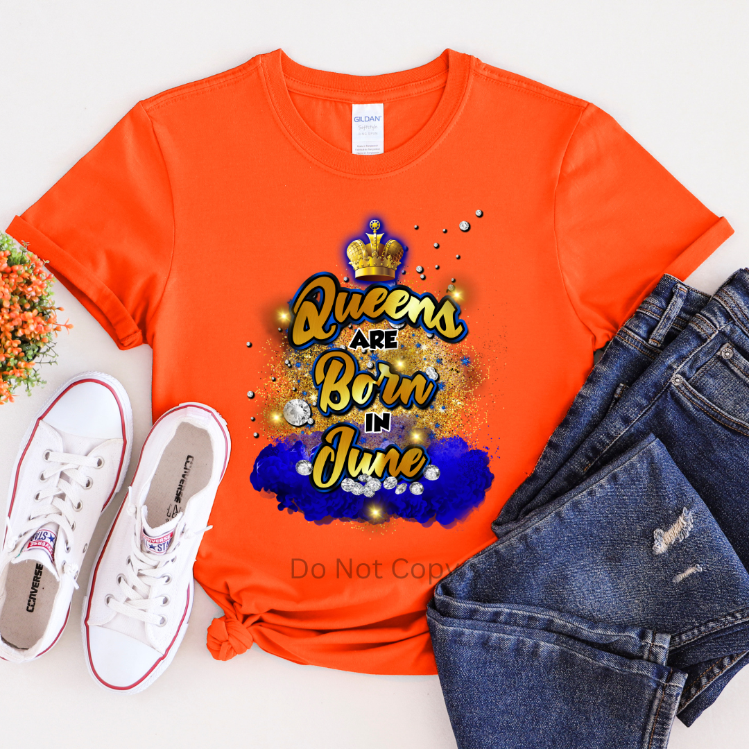 An orange T-shirt with the text 'Queens are Born in June' printed on it, displayed alongside white sneakers and blue jeans.