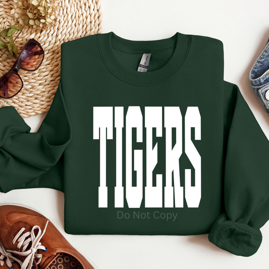 Green sweatshirt with 'TIGERS Do Not Copy' text on a white surface with accessories.