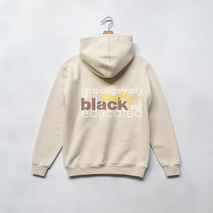 A cream-colored hoodie hanging on a wooden hanger against a light gray background, featuring a graphic text print on the back in white, yellow, and brown.