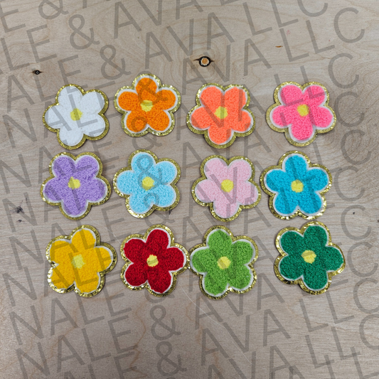 Colorful flower-shaped objects on a textured surface with 'Nail &' branding.