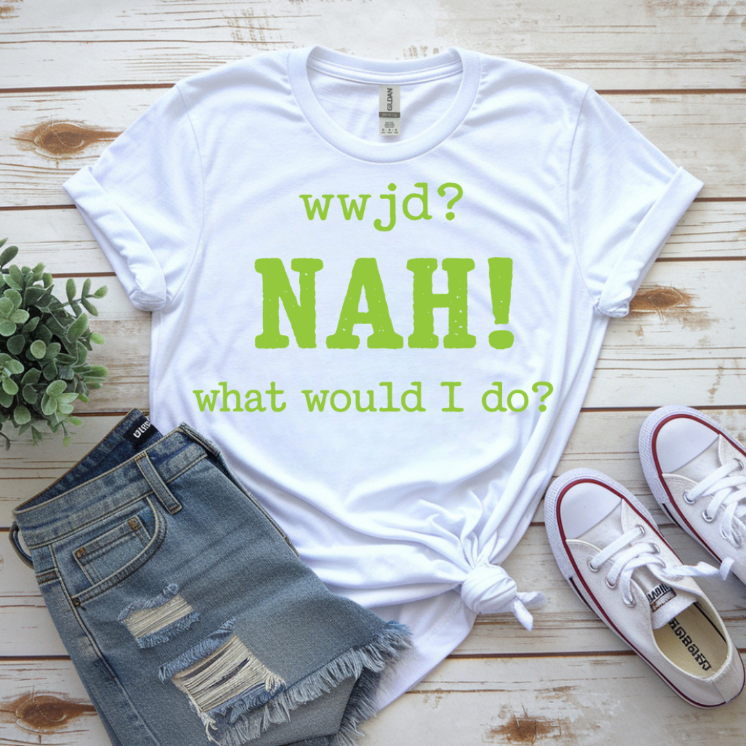 White t-shirt with green text on a wooden surface with jeans and sneakers.