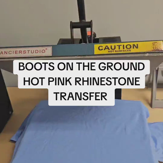 Video demonstration of how to apply a hot pink and silver rhinestone heat transfer to a cotton t-shirt using a commercial heat press at 330°F for 30 seconds.